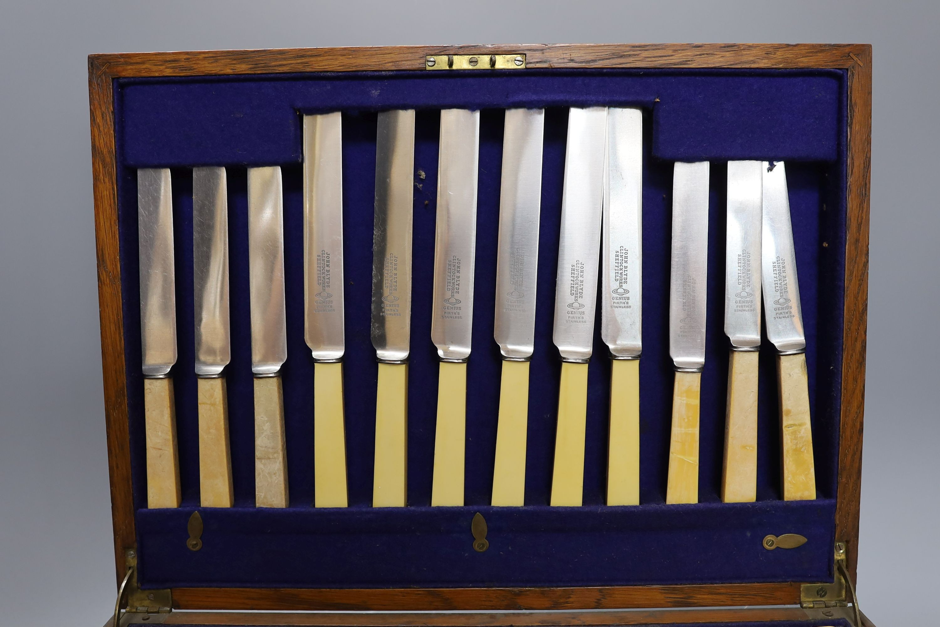 A three decanter tantalus - with labels, together with an oak canteen of table plated cutlery